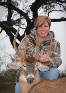 female hunter presenting deer kill, unique horns
