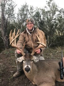 Hunter with a deer scope presenting fresh kill