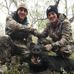 hunter twins, holding fresh boar kill