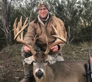 hunter posing with deer with large trophy rack