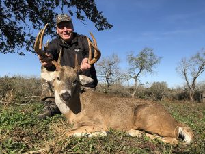 man holding deer by his antlers | Hooville Ranch hunting and lodging